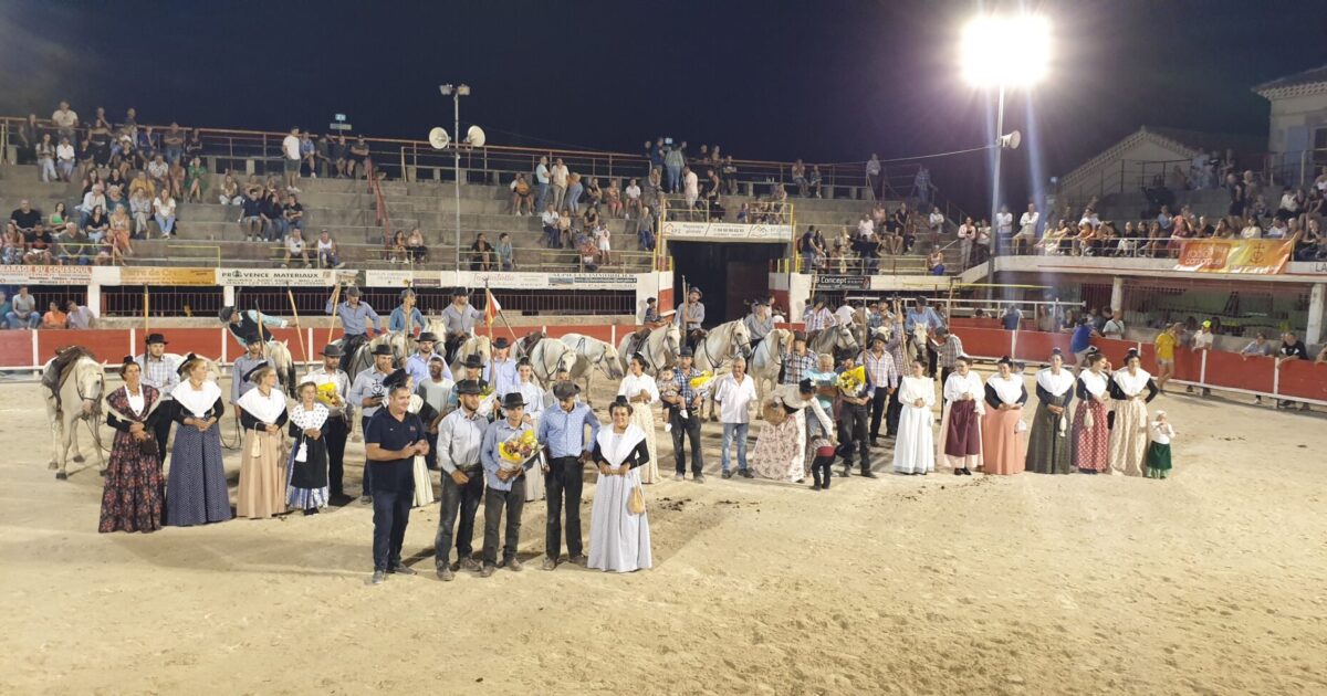 photo des arènes avec les représentants des manades abordant des trophées et les arlésiennes lors de Olympiades Camarguaises